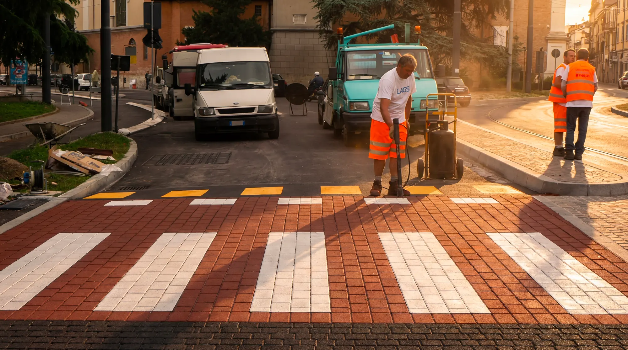 Operatore al lavoro su un attraversamento pedonale in asfalto stampato effetto mattone